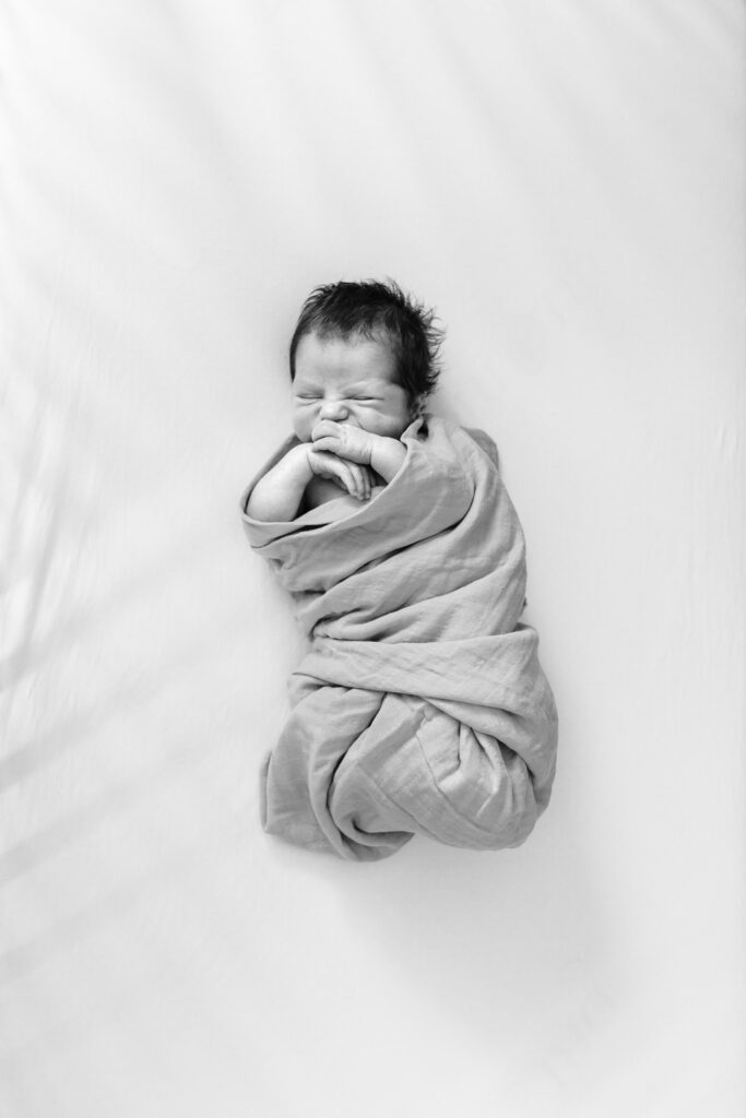 newborn baby sleeping wrapped in blanket