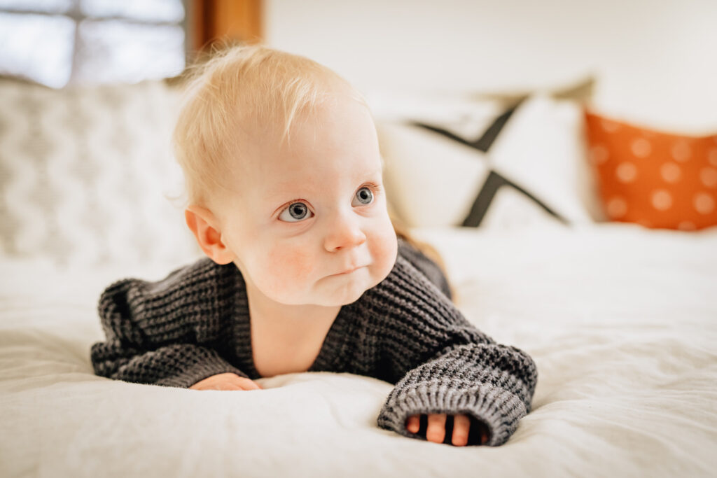 1 year old baby lying on stomach on bed