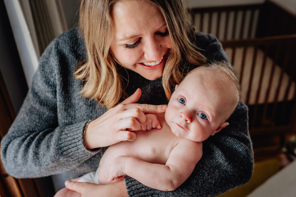 parent smiling touching on face 3 month baby in diaper