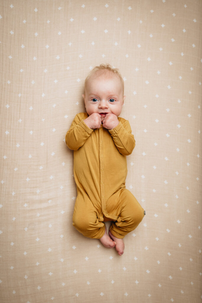 smiling 3 month baby in grow sleeper suit