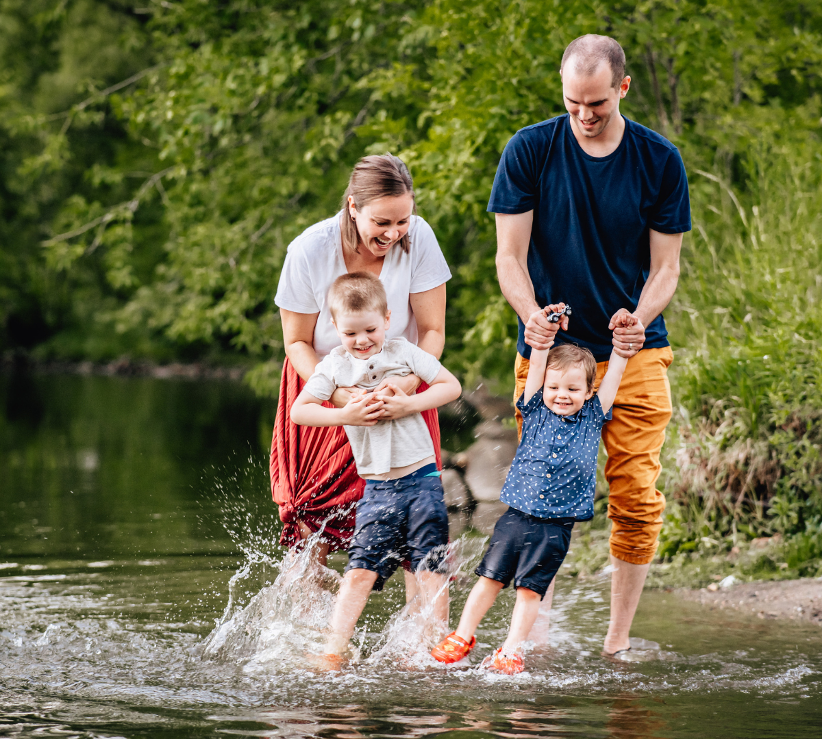 family playing together outside in the water, mother, father, and two sons