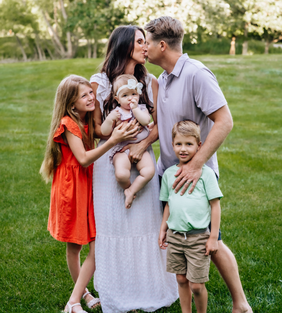 family outside on lawn with mother, father, their son, and two daughters