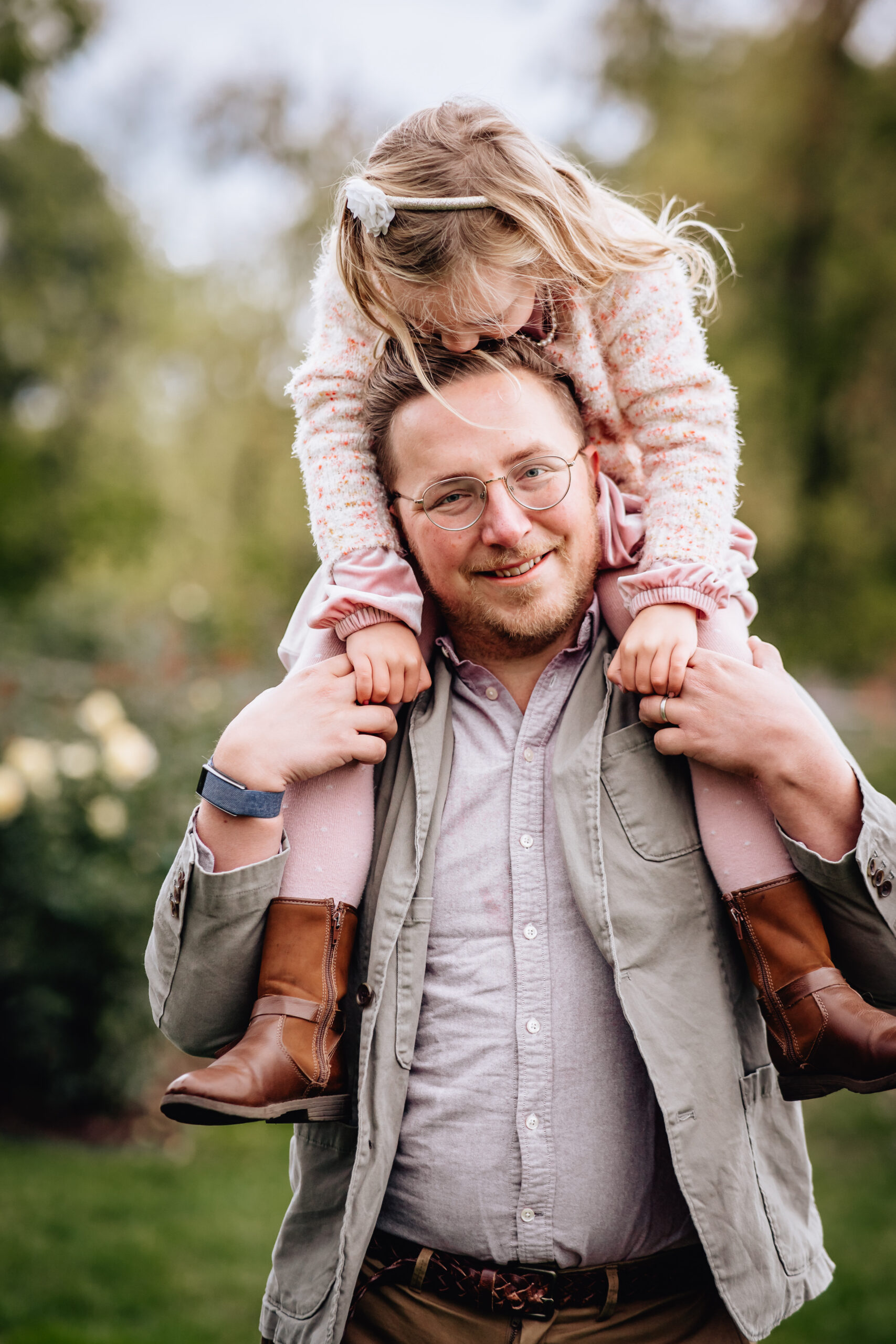 father holding his young daughter on his shoulders