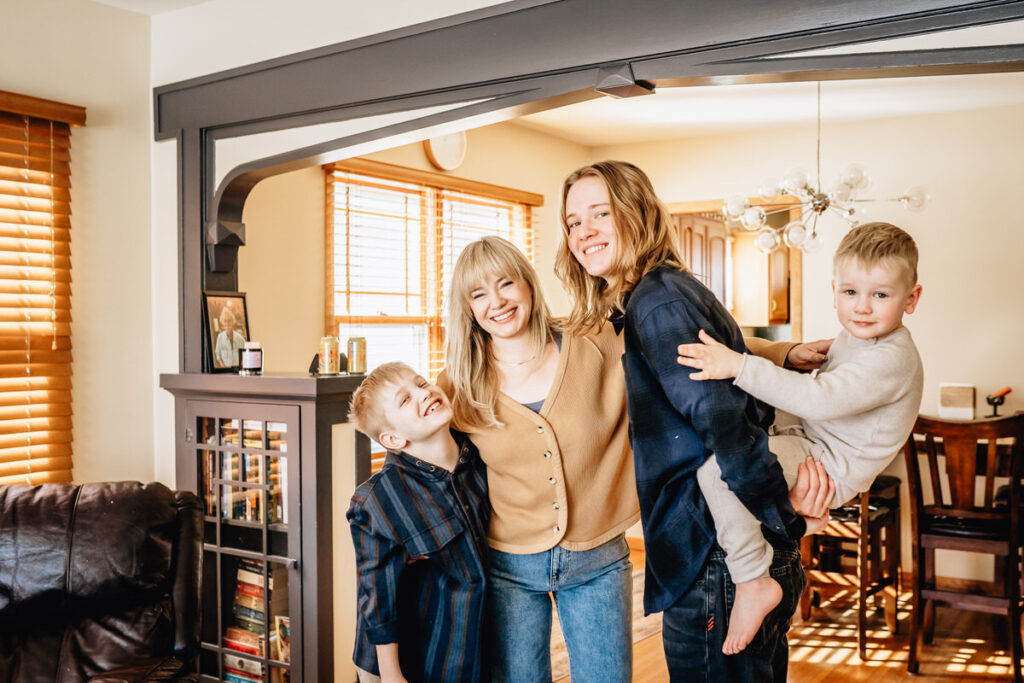 a family standing together in a living room, with children smiling and hugging each other