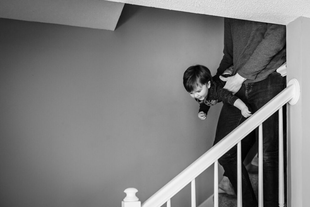 a child being playfully carried down a staircase by an adult