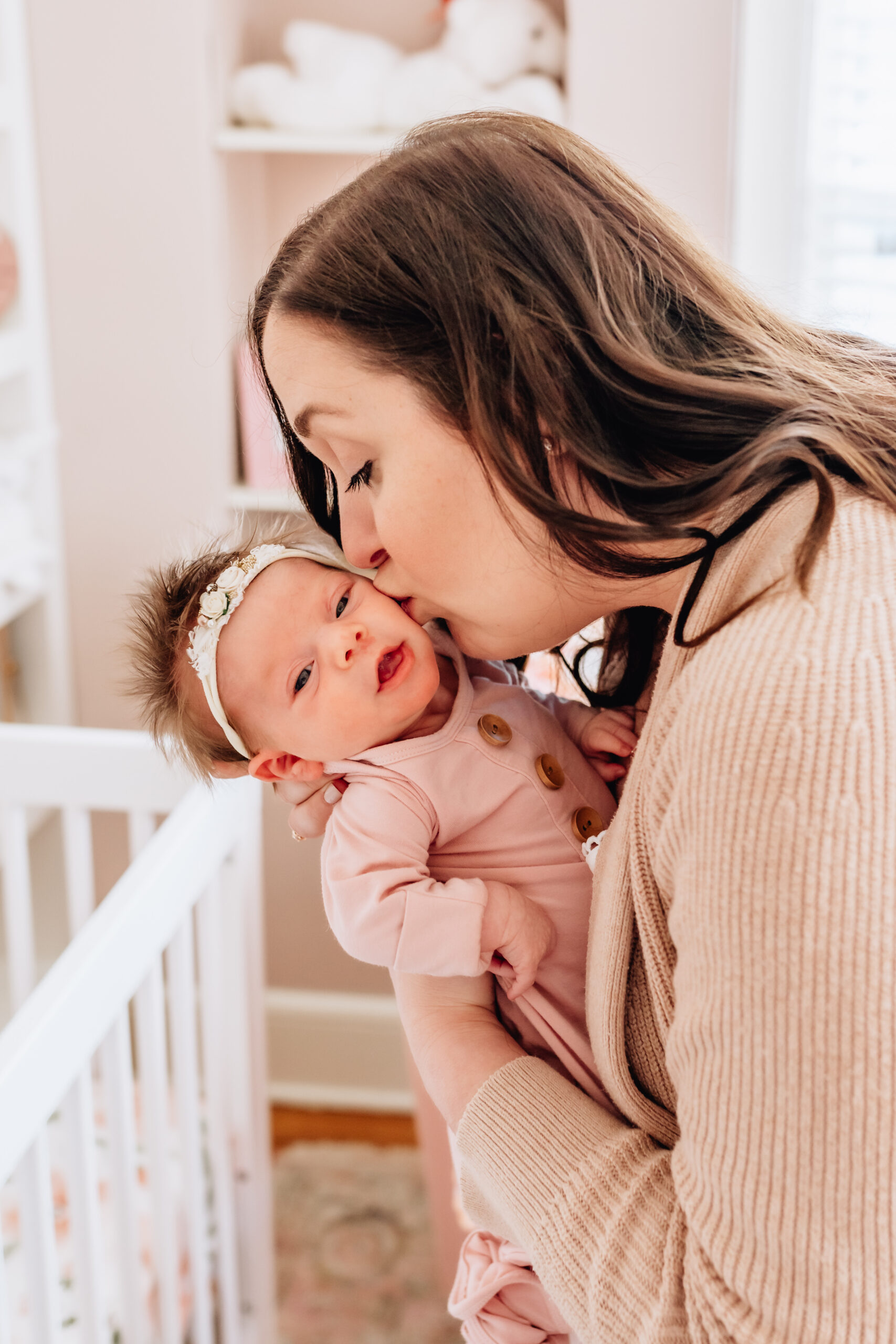 Mother kissing her newborn daughter.